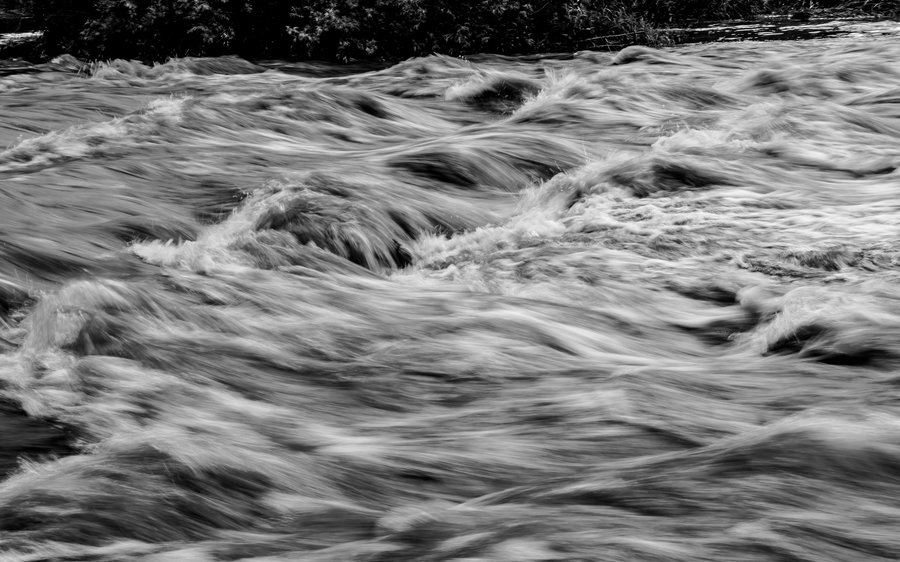 Floodwater rushing through a swollen river