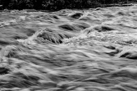 Floodwater rushing through a swollen river